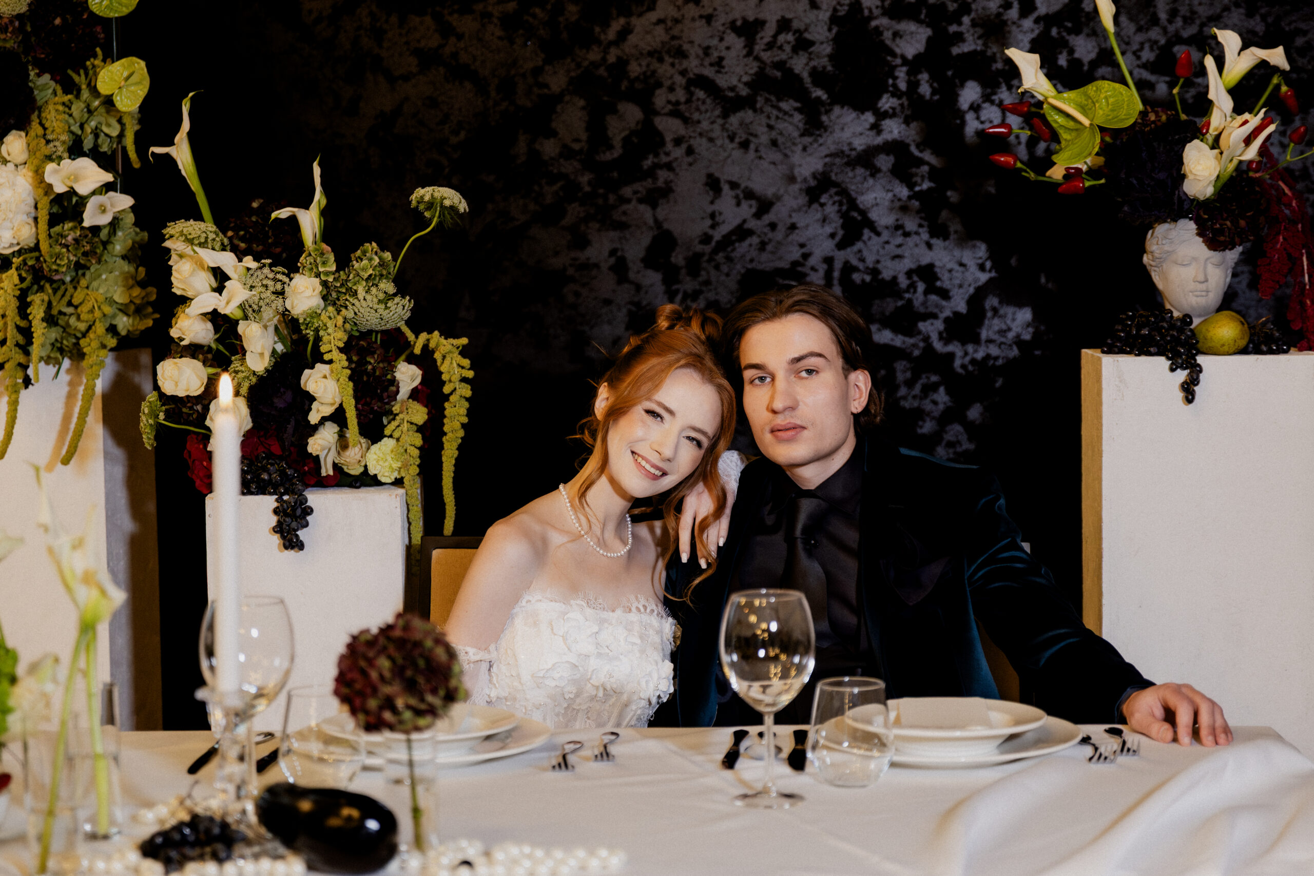 Realizacje dekoracji weselnych Badylara – para młoda przy stole na tle aranżacji kwiatowej